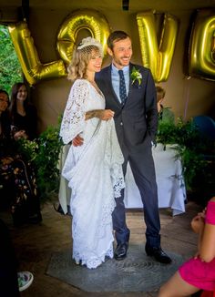 a bride and groom are standing in front of the love sign at their wedding reception