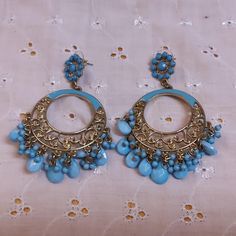 These beautiful pieces are Long Circular Goldtone Filigree Pierced Earrings Enhanced with Blue Enamel and Blue Stone Drops. The Stud is a Goldtone Circle Enhanced with Blue Stones with the longer Filigree section below. No maker's mark found. Used but in excellent condition. Dimensions are 3 inches by 2 inches. Traditional Blue Drop Chandelier Earrings, Blue Metal Chandelier Earrings With Dangling Beads, Traditional Blue Danglers For Pierced Ears, Traditional Blue Danglers, Blue Metal Dangle Hoop Earrings, Blue Pierced Drop Chandelier Earrings, Blue Metal Chandelier Earrings For Pierced Ears, Blue Metal Bohemian Chandelier Earrings, Bohemian Blue Metal Chandelier Earrings