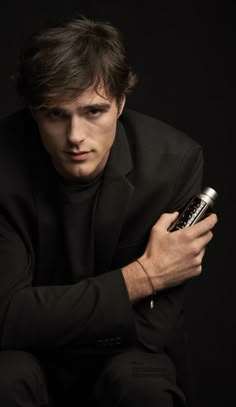 a man in a black suit holding a cell phone