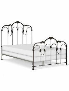 an iron bed frame with white sheets and headboard