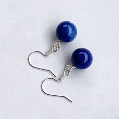 These blue dangle earrings add the perfect POP of beautiful royal blue color to any outfit!  Silver fish hooks featuring a 10mm round dark blue gemstone beaded dangle and measuring 1.25 inches in length.  Simple, yet lovely! Item is carefully packaged and shipped via USPS in a sturdy protective mailer. Check out more fabulous jewelry and enter my shop here: https://www.etsy.com/shop/jewelbytessyla View the positive feedback I've received from customers and check out some beautiful art prints for nursery and home at my print shop, Tessyla:   https://www.etsy.com/shop/Tessyla Thanks for looking and have a great day! Royal Blue Earrings, Simple Blue Earrings, Round Blue Dangle Earrings, Navy Dangle Earrings, Blue Gemstone Earrings, Navy Blue Earrings Blue Single Earring As Gift, Blue Round Earrings For Pierced Ears, Adjustable Blue Drop Earrings, Elegant Blue Round Earrings, Blue Hypoallergenic Earrings With Round Beads, Blue Hypoallergenic Drop Earrings, Blue Single Sterling Silver Earring, Blue Sterling Silver Single Earring, Single Blue Sterling Silver Earring