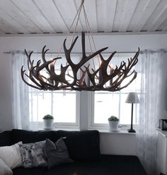 a living room filled with furniture and a large antler chandelier hanging from the ceiling