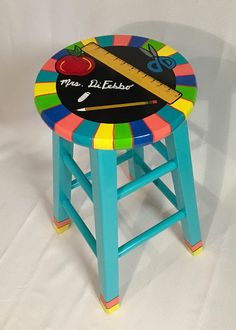 a colorful stool with a ruler and apple on it