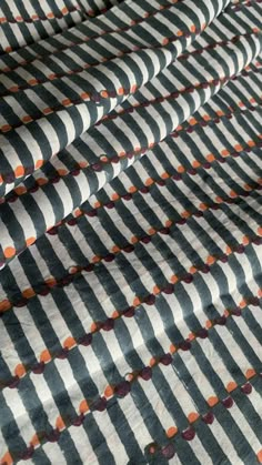 an orange and black striped fabric with circles on it's edges is shown in close up