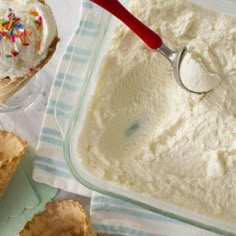 two ice cream cones with sprinkles and a spoon