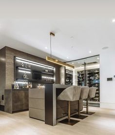 a large open kitchen with bar stools next to it