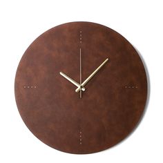 a clock made out of brown leather with gold hands and numbers on the face is shown