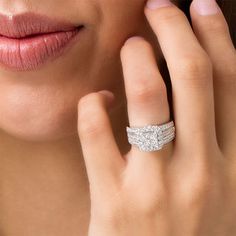 a woman wearing a diamond ring with her hand on her face and the other hand to her ear