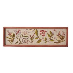 an embroidered wall hanging with flowers and leaves on it's side, in red frame