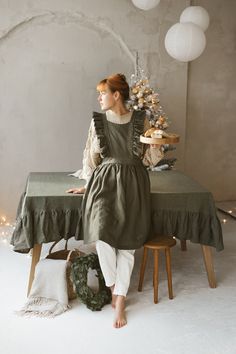 Long vintage apron is made from 100% soft and washed medium weight linen.  Details: - Composition: 100% natural linen - Cross back - Flutter sleeves - Size: One size The model is 173 cm/5'8" and wears a size one size. Machine washable & tumble dry low, ironing optional The apron color in a photo is Forest green 100% NATURAL LINEN FIBER TESTED FOR HARMFUL SUBSTANCES ACCORDING TO OEKO-TEX STANDARD Cottagecore Apron Outfit, Cottagecore Dress With Apron, Cottagecore Pinafore, Cottagecore Apron, Cooking Apron Cottage Core, Victorian Maid, Vintage Pinafore, Linen Apron Dress, Green Apron