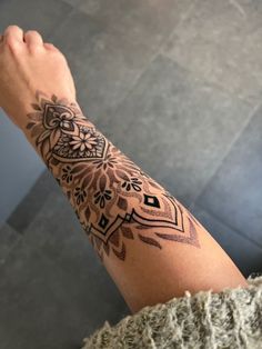 a person's arm with a tattoo on it and an intricate design in the middle