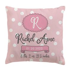 a pink pillow with white polka dots and a monogrammed r on the front