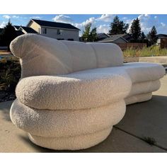 two white couches sitting on top of a sidewalk