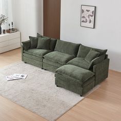 a green couch sitting on top of a white rug in a living room next to a window