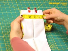 someone is measuring the length of a pair of white cloths with a tape measure