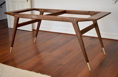 a wooden table sitting on top of a hard wood floor next to a planter