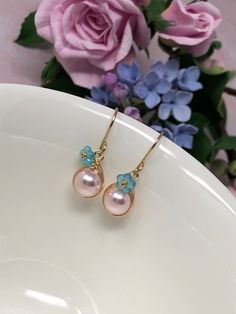 These one of a kind flowering beauties feature soft, blush pink Swarovski Crystal pearls that are meticulously wrapped in 14kt yellow gold filled wire. The braided detailing looks amazing with these pearls. Accented with gold-dusted, aqua Czech glass flowers and gracefully suspended from handcrafted French ear wires. These are perfect for Spring, Summer and for bridesmaids gifts! - All components are 14kt yellow gold filled. - Swarovski Crystal pearls, Czech Glass flower beads. - Pearl dangles a Glass Flower Earrings, Earrings Gold Pearl, Pink Pearl Earrings, Pearl Earrings Gold, Pearl Drop Earrings Gold, Malachite Earrings, Easter Earrings, Lapis Lazuli Jewelry, Spring Earrings