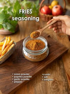 a person is spooning some seasoning into a jar with french fries on the side