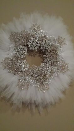 a white wreath with silver sequins and feathers