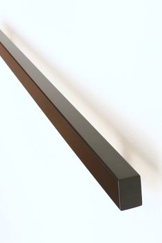 a close up of a metal shelf against a white wall