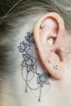 a woman's behind the ear tattoo is shown