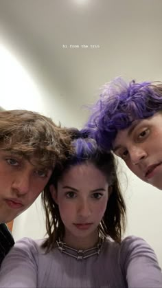 three young people with purple hair standing in front of a mirror