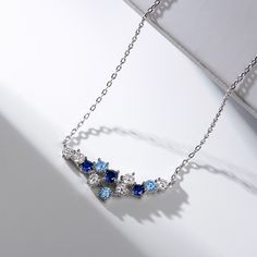 Dazzling with colour, this fashion necklace is certain to receive instant compliments. Created in sterling silver, this intriguing style showcases an array of stones - light blue, midnight blue and white stones - all placed along a curved bar design. Add this masterpiece to your jewelry box and you won't be disappointed.Carat Weight: 3.07 ctStone Size: 3,3.5,3 mmStone Type: Jeulia® StoneNumber of Stones: 12 Stone Shape: RoundStone Color: Diamond White, Aquamarine Blue, Sapphire BlueWeight: 2.1 g Blue Sapphire Gemstone Necklaces, Blue Sapphire Gemstone Necklace, Blue Crystal Jewelry With Gemstones, Blue Fine Jewelry Necklace As Gift, Fine Jewelry Blue Necklace For Gift, Blue Fine Jewelry Necklace For Gift, Blue Sapphire Pendant Necklaces, Blue Stones Fine Jewelry, Fine Jewelry With Blue Stones