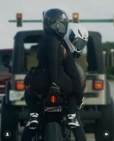 two people riding on the back of a motorcycle