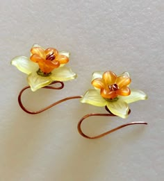 "Darling lightweight yellow daffodils with orange centers dangle on handmade natural copper hooks of 20 gauge German copper wire. Delicate lucite daffodil flower measures 20 mm wide and is embellished with bright orange lucite center flower and tiny lacey copper bead caps. Total length is 1\". Darling springtime accessory!" Orange Daffodils, Bright Copper, Yellow Daffodils, Daffodil Flower, Piercings Jewelry, Flowers Handmade, Dope Jewelry, Earrings Flower, Funky Jewelry