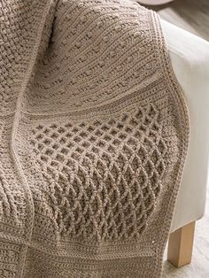 a crocheted blanket sitting on top of a white couch