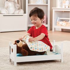 a little boy that is playing with a teddy bear