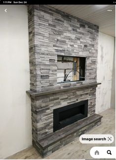 an empty room with a stone fireplace in it