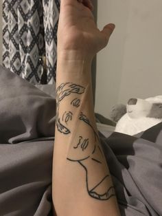 a woman's arm with a tattoo on it that has a drawing of a man