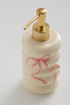 a soap dispenser with pink and gold designs on it