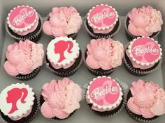 cupcakes with pink frosting and white icing in a box that says barbie