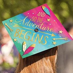 a woman wearing a colorful graduation cap that says and so the adventure begins