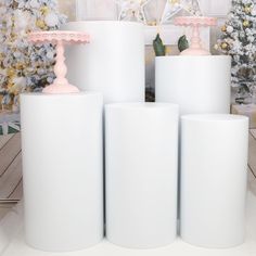 three large white vases sitting next to each other in front of a christmas tree