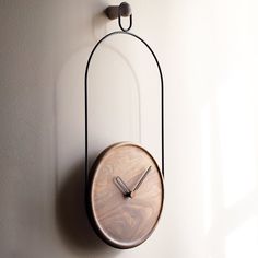 a clock mounted to the side of a wall next to a glass bowl on a table