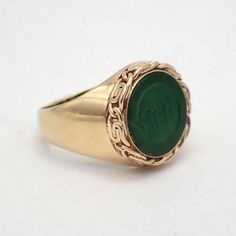 Vintage 14k (.585) yellow gold round form signet ring with a green Jade inset, featuring carved symbols, and outlined with ornate bezel. This glorious ring is a size 5, it is 13.2 mm wide, weighing 4.2 grams. EA4848 Green Signet Ring, Carved Yellow Gold Rings, Formal Oval Carved Signet Ring, Formal Carved Yellow Gold Signet Ring, Carved Engraved Yellow Gold Ring, Formal Carved Rings In 14k Gold, Formal Carved 14k Gold Ring, Formal 14k Gold Carved Rings, Antique Carved Signet Ring