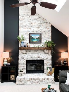 a living room with a fire place and ceiling fan in it's centerpiece