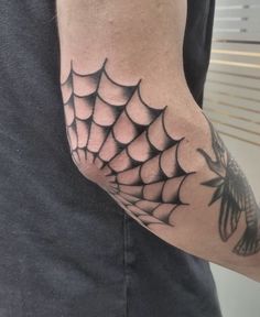 a man with a spider web tattoo on his arm