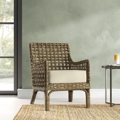 a wicker chair sitting on top of a rug next to a table