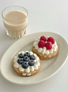 two desserts on a plate next to a glass of milk