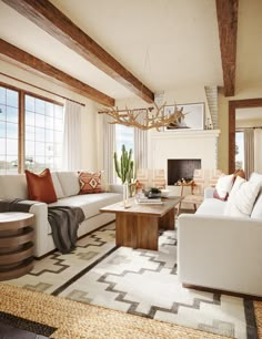 a living room filled with furniture and a fire place in front of a window on top of a rug