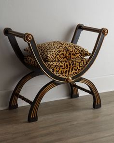 a leopard print chair sitting on top of a hard wood floor next to a white wall