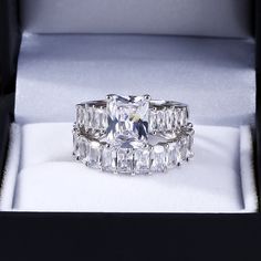 Classic, elegant and symbolic of your everlasting love, this ring will win her heart. It showcases a sparkling radiant cut center stone that catches the eye. Additional radiant stones adorn the ring's shank and matching band. On your special day, a coordinating band completes this unique and intriguing ensemble. An awesome look of love, this beautiful ring set is certain to leave her spellbound.Carat Weight: 3.85 ctStone Size: 7*9 mmStone Type: Jeulia® StoneNumber of Stones: 1 Stone Color: Diamond WhiteStone Shape: BaguetteCarat Weight: 12.74 ctStone Size: 3*5 mmStone Type: Jeulia® StoneNumber of Stones: 26 Stone Color: Diamond WhiteStone Shape: BaguetteWeight: 12.95 gWidth: 15.58 mmHeight: 5.6 mmThickness: 5.1 mmMaterial: 925 SilverPlating Color: Silver White Sapphire Wedding Set, Jeulia Jewelry, Large Rings, Unique Ring Designs, Look Of Love, Handmade Engagement Rings, Sterling Silver Rings Set, Swarovski Crystal Jewelry, Princess Cut Engagement Rings