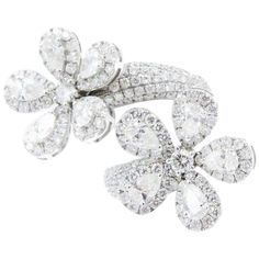 The lustrous harmony of 18k white gold and diamonds is highlighted in this beautifully handcrafted fancy double flower ring. Add sparkle to your fingers with these glistening blossoms, blooming with 5.06cts of diamonds. Each flower contains 61 shimmering diamonds and rows of diamonds also cover the stylish spiral band. Make a statement. Say it with flowers! Say It With Flowers, Green Diamond Rings, Pear Cut Ring, Flower Rings, Gold Amethyst Ring, Gold Flower Ring, Expensive Jewelry Luxury, Fancy Yellow Diamond, Spiral Ring