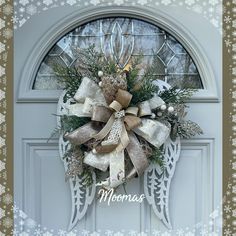 the front door is decorated with an angel's wings wreath and bow for christmas