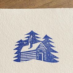 a piece of paper with blue ink that has a house in the woods on it