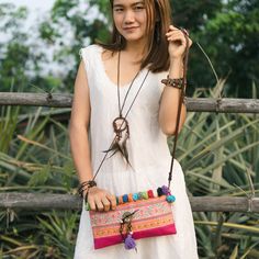 "This beautiful crossbody bag is made with an amazing piece of fabric woven by the HMONG hill tribes of Lanna Country (Northern Thailand). It decorate with multi pom pom. It features a zippered opening area, inside zippered pocket and removable strap. It's a great bag for carrying anything. We buy materials from Hmong market and we design and sew by hand. Some of the bags we modify to improve the product. The Hmong tribes live in the North of Thailand and have origins from the Tibetan area of Ch Bohemian Handheld Shoulder Bag With Removable Pouch, Embroidered Crossbody Shoulder Bag For Travel, Bohemian Style Clutch Shoulder Bag For Travel, Bohemian Clutch Shoulder Bag For Travel, Bohemian Clutch Shoulder Bag With Adjustable Strap, Bohemian Everyday Use Pouch, Embroidered Clutch Shoulder Bag For Travel, Bohemian Pouch Clutch With Adjustable Strap, Bohemian Crossbody Mobile Phone Bag